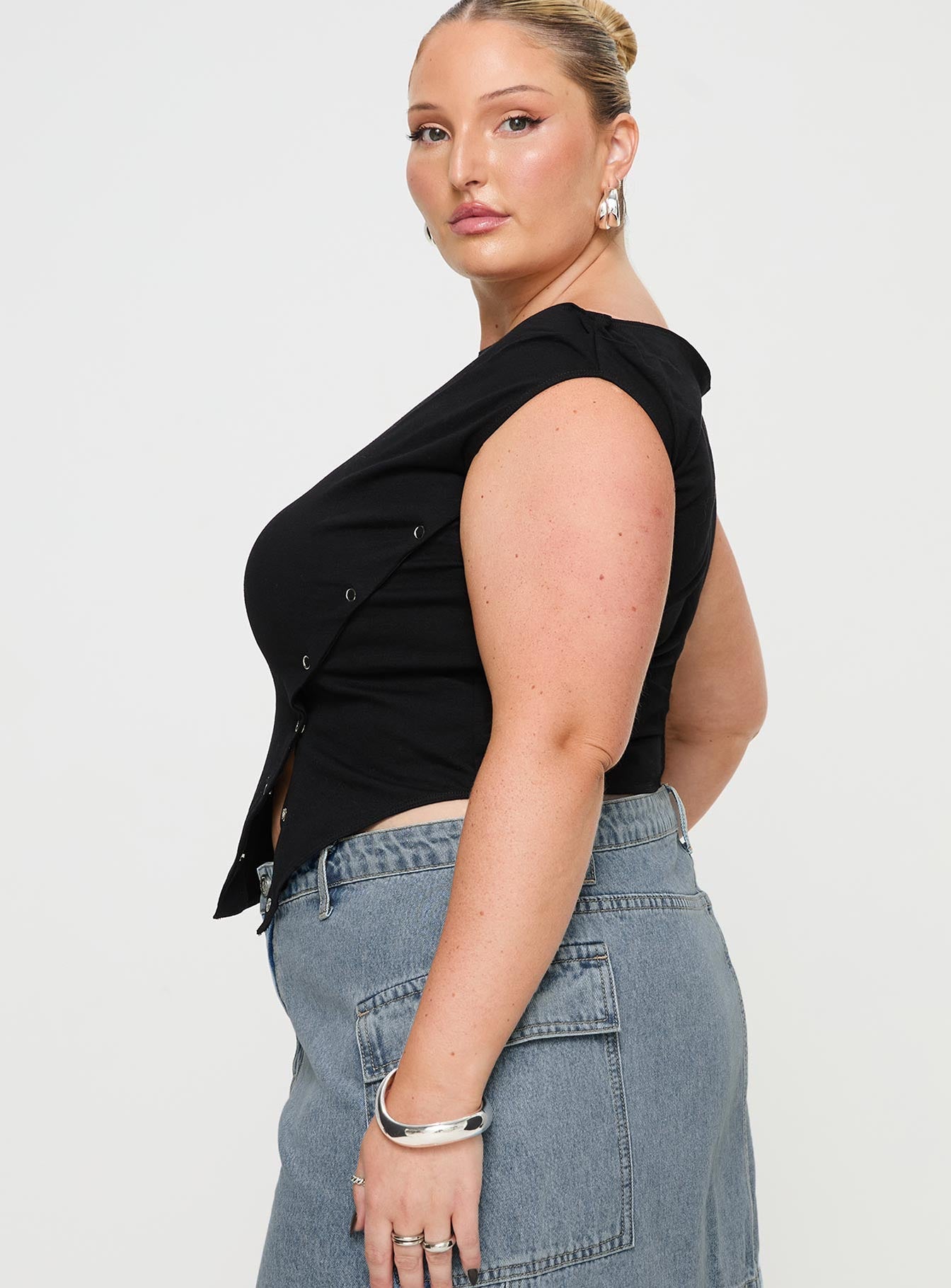 side view of model wearing Princess Polly Karre Off The Shoulder Top Black Curve Sleeveless Asymmetric Neckline 