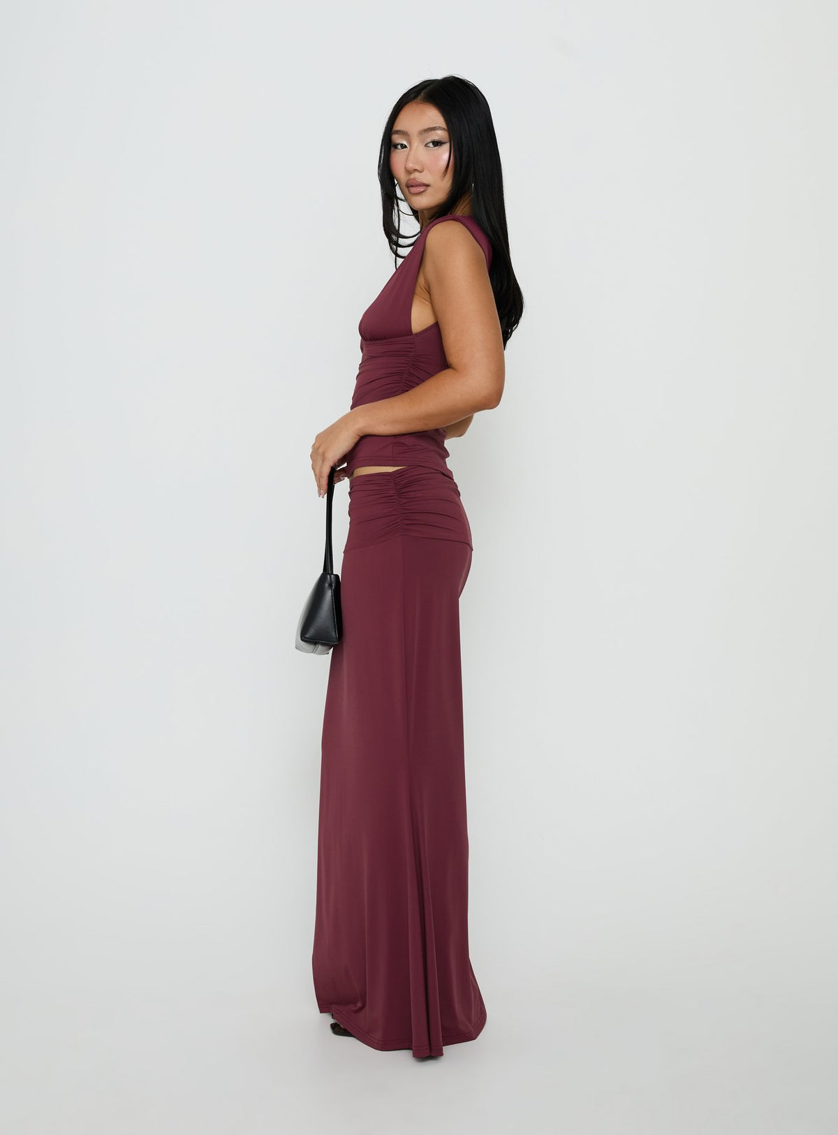 Highlighting the Liorah Foldover Waist Maxi Skirt Red in womens-skirts with a maxi length side view of model wearing Princess Polly