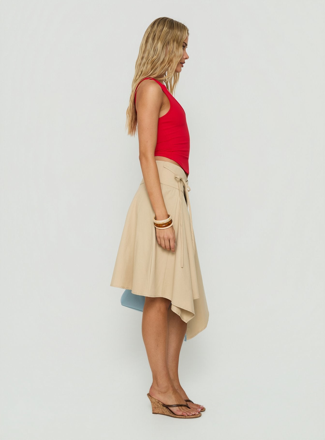 Featuring the Ellainah Asymmetrical Wrap Midi Skirt Concrete in tan womens-skirts with relaxed fit side view of model wearing Princess Polly