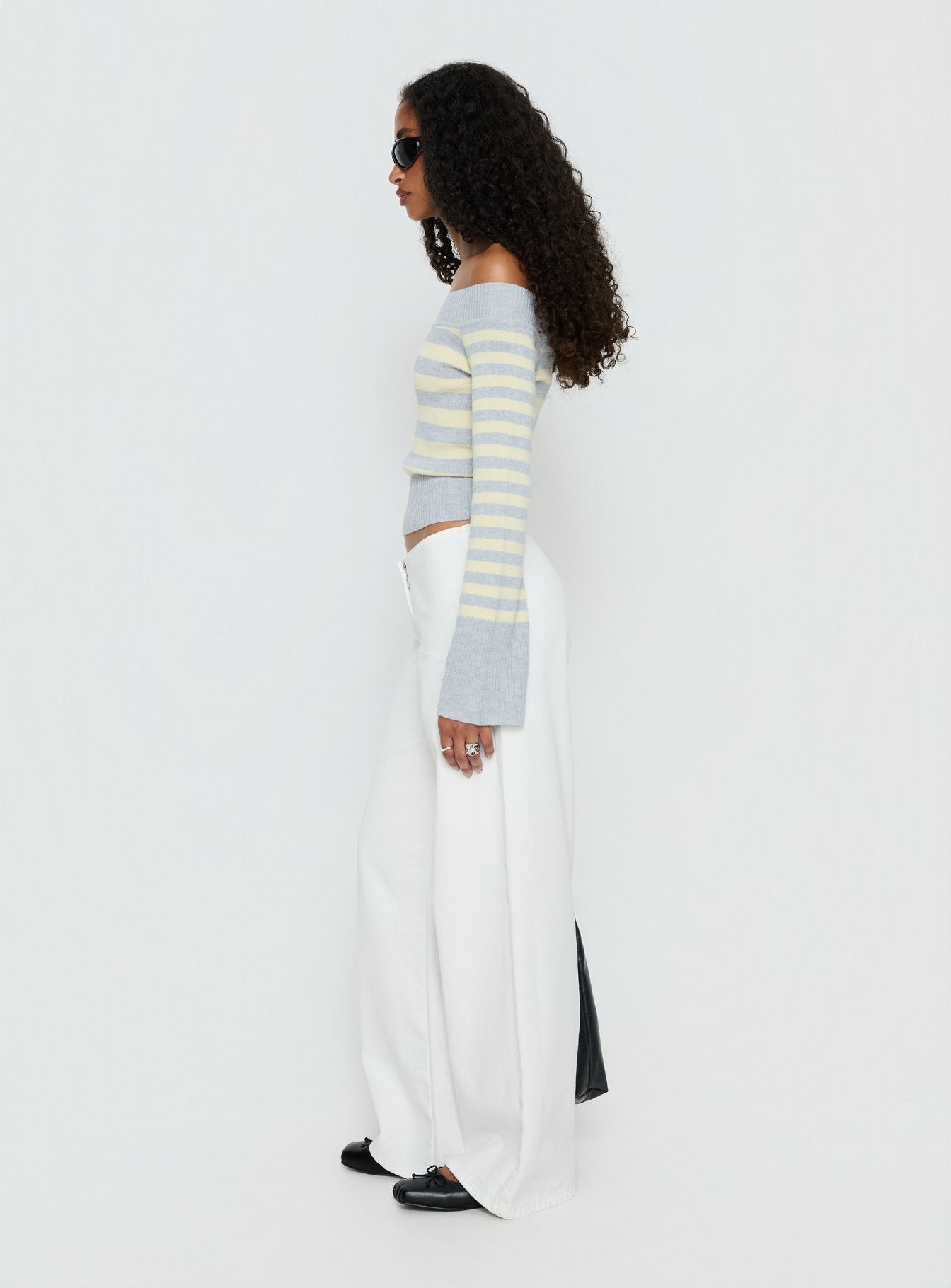 side view of model wearing Princess Polly Hereos Mid Rise Baggy Leg Jeans White Mid Rise Jeans 