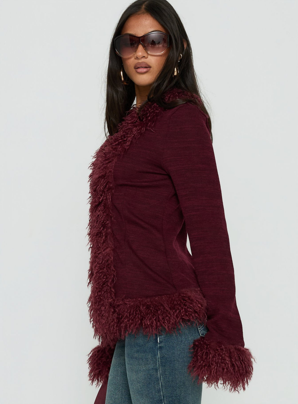 Featuring the Brynlie Faux Fur Trim Boxy Cardigan Burgundy womens jumper with short length side view of model wearing Princess Polly