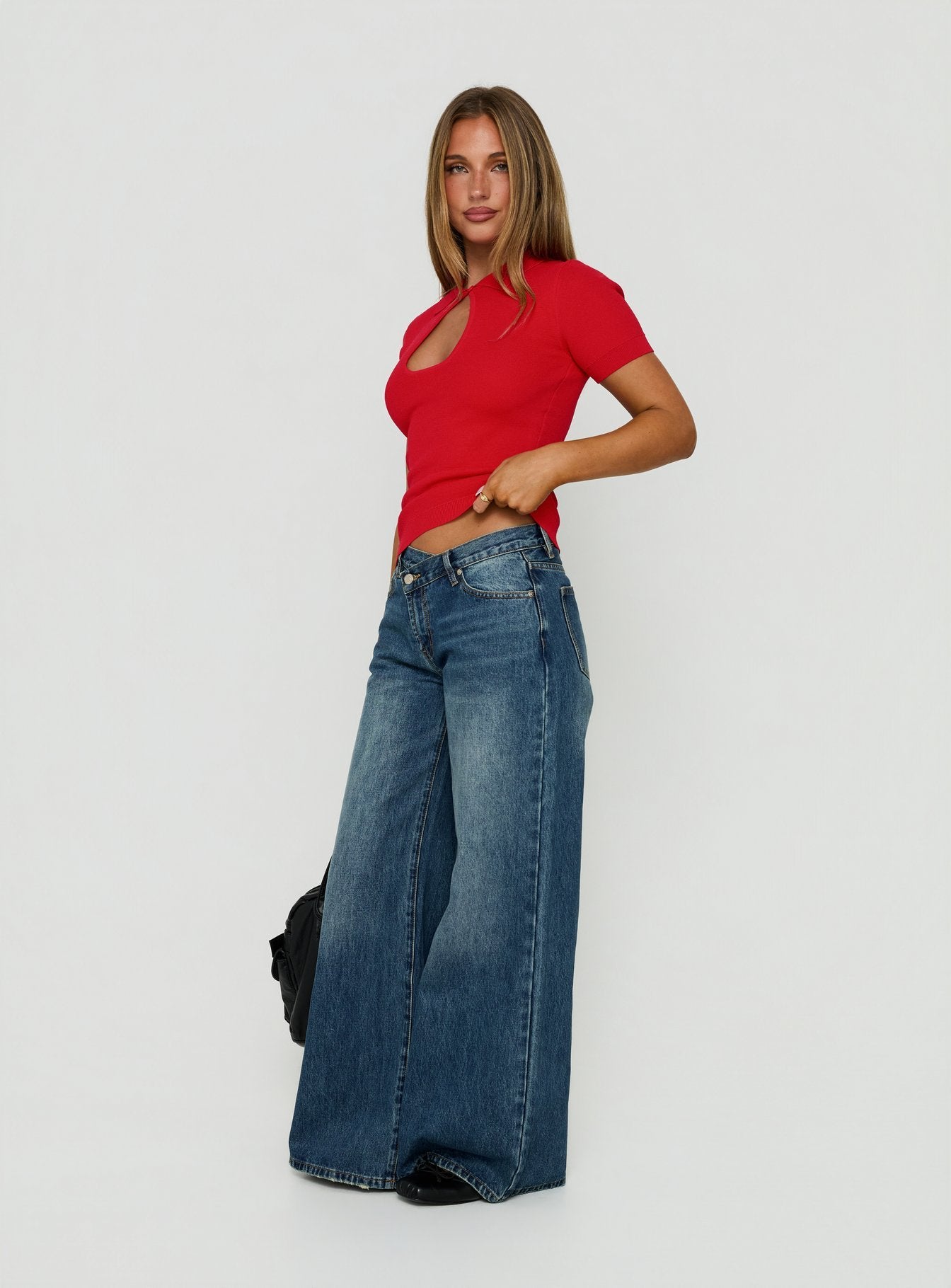 Crafted from Celinia Mid Rise Asymmetrical Baggy Jeans Dark Indigo womens-jeans with mid-rise side view of model wearing Princess Polly