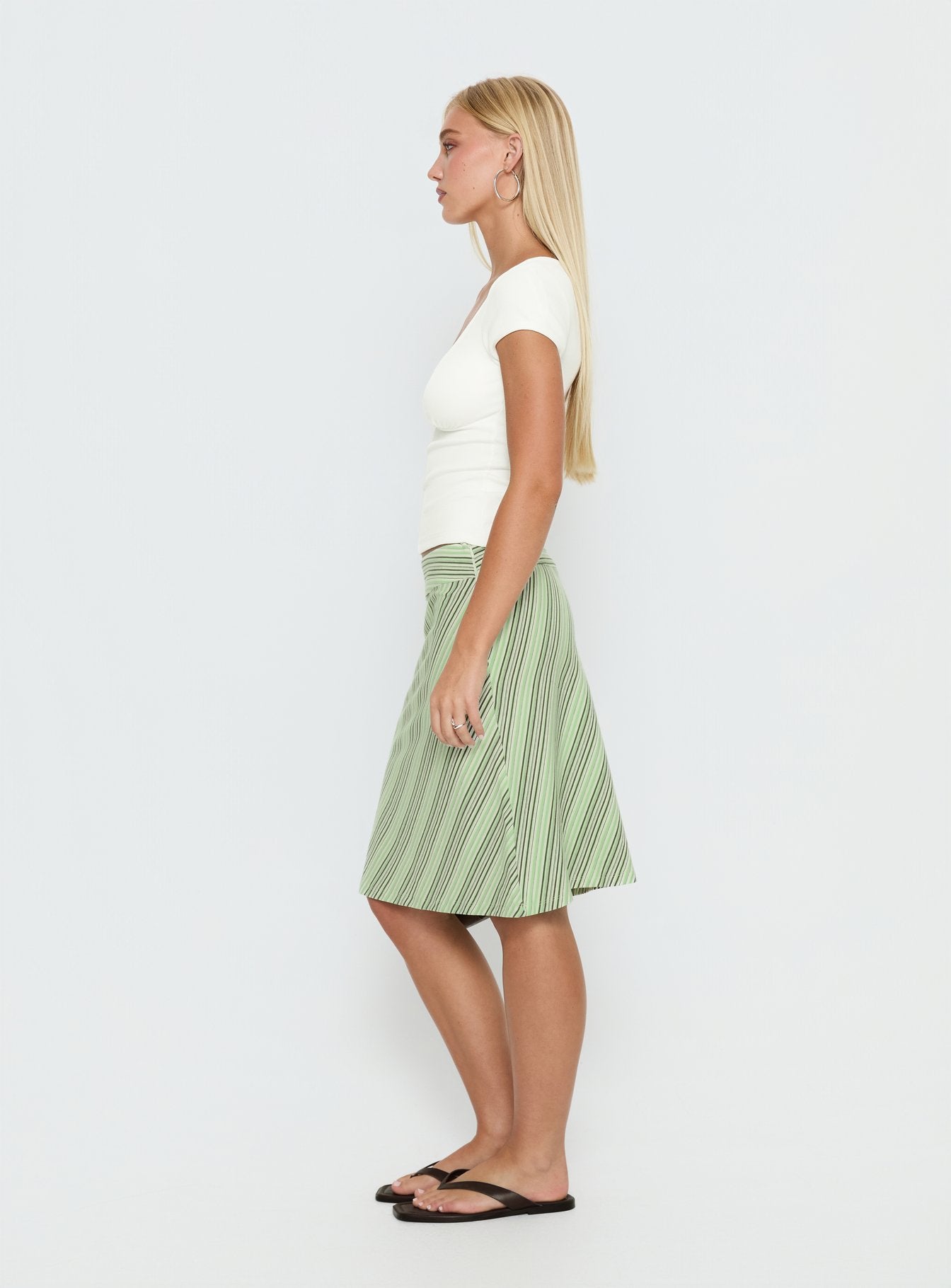   side view of model wearing Princess Polly Lemon Twist Midi Skirt Green Stripe Knee 