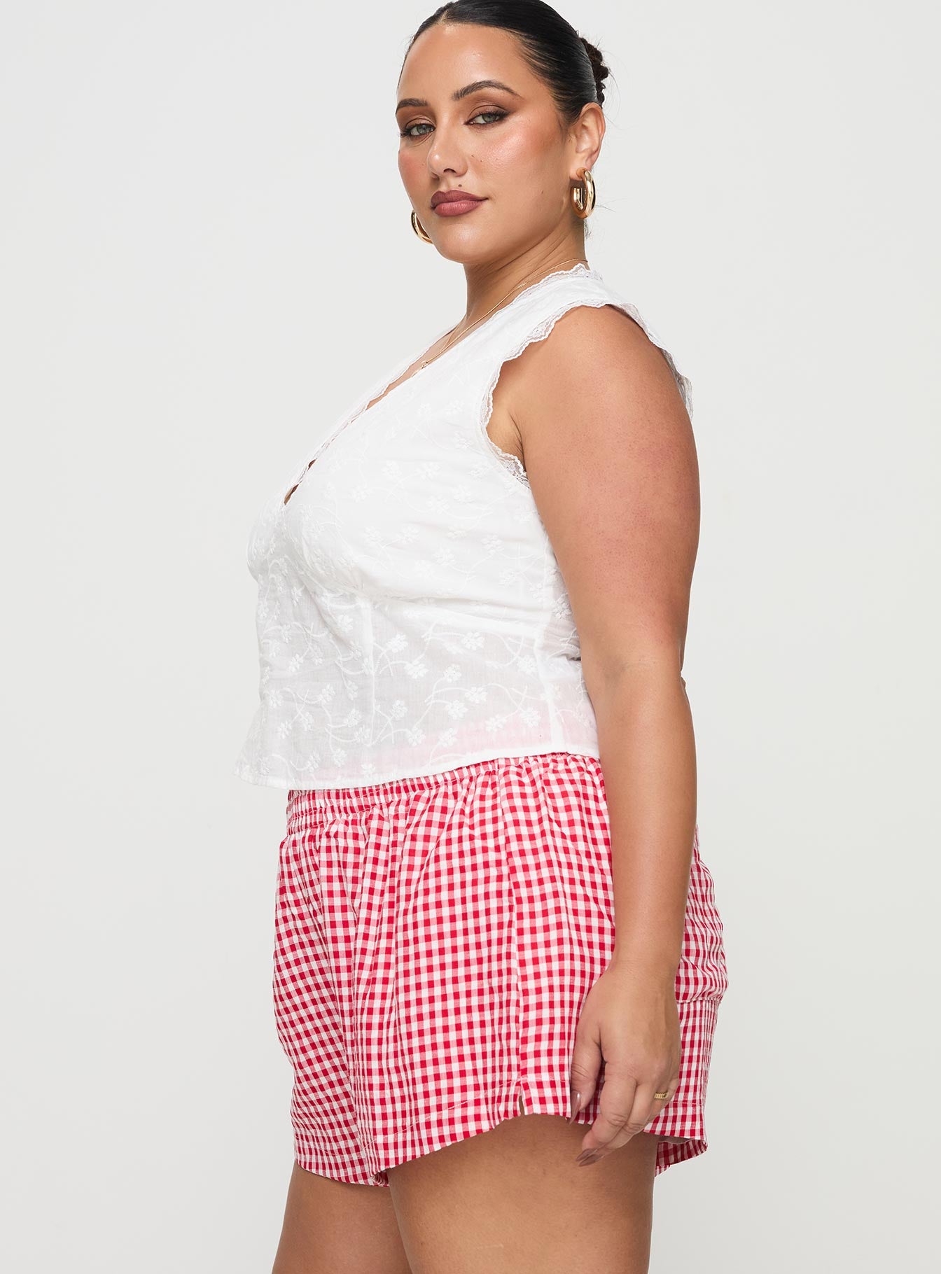 side view of model wearing Princess Polly Beach House Shorts Red / White Gingham Curve 