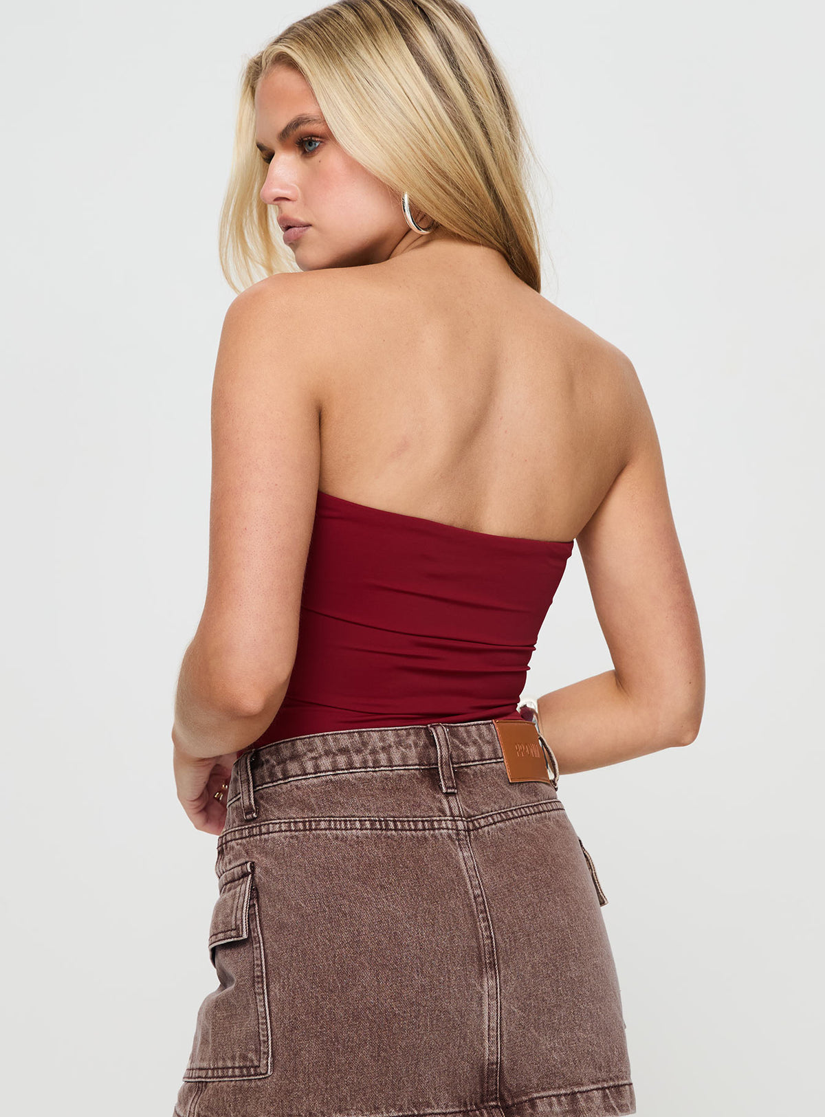 back view of model wearing Princess Polly Niner Strapless Bodysuit Burgundy Petite Sleeveless Bodysuit 