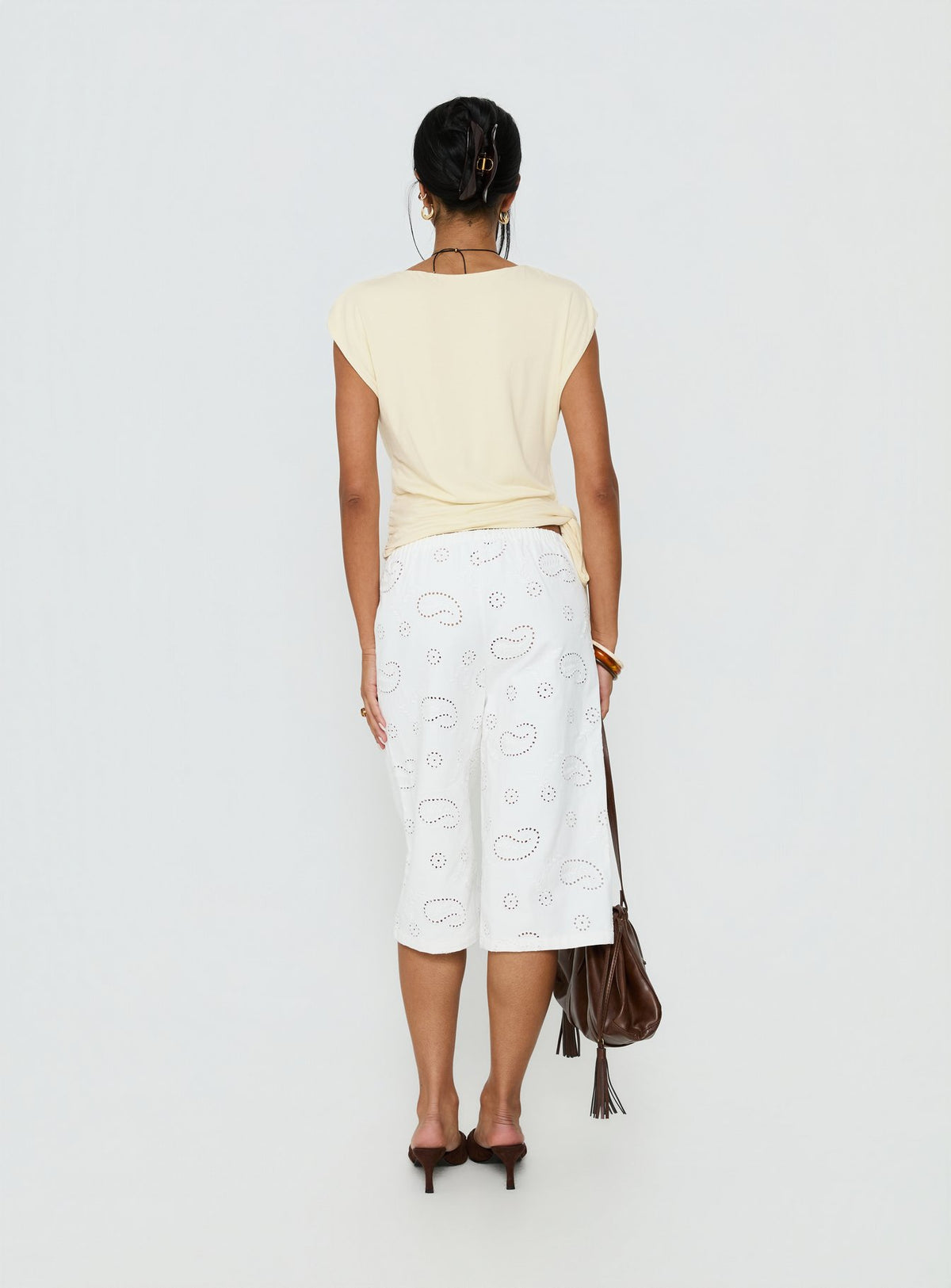 back view of model wearing Princess Polly Roda Anglaise Longline Shorts White Mid Rise Pants 