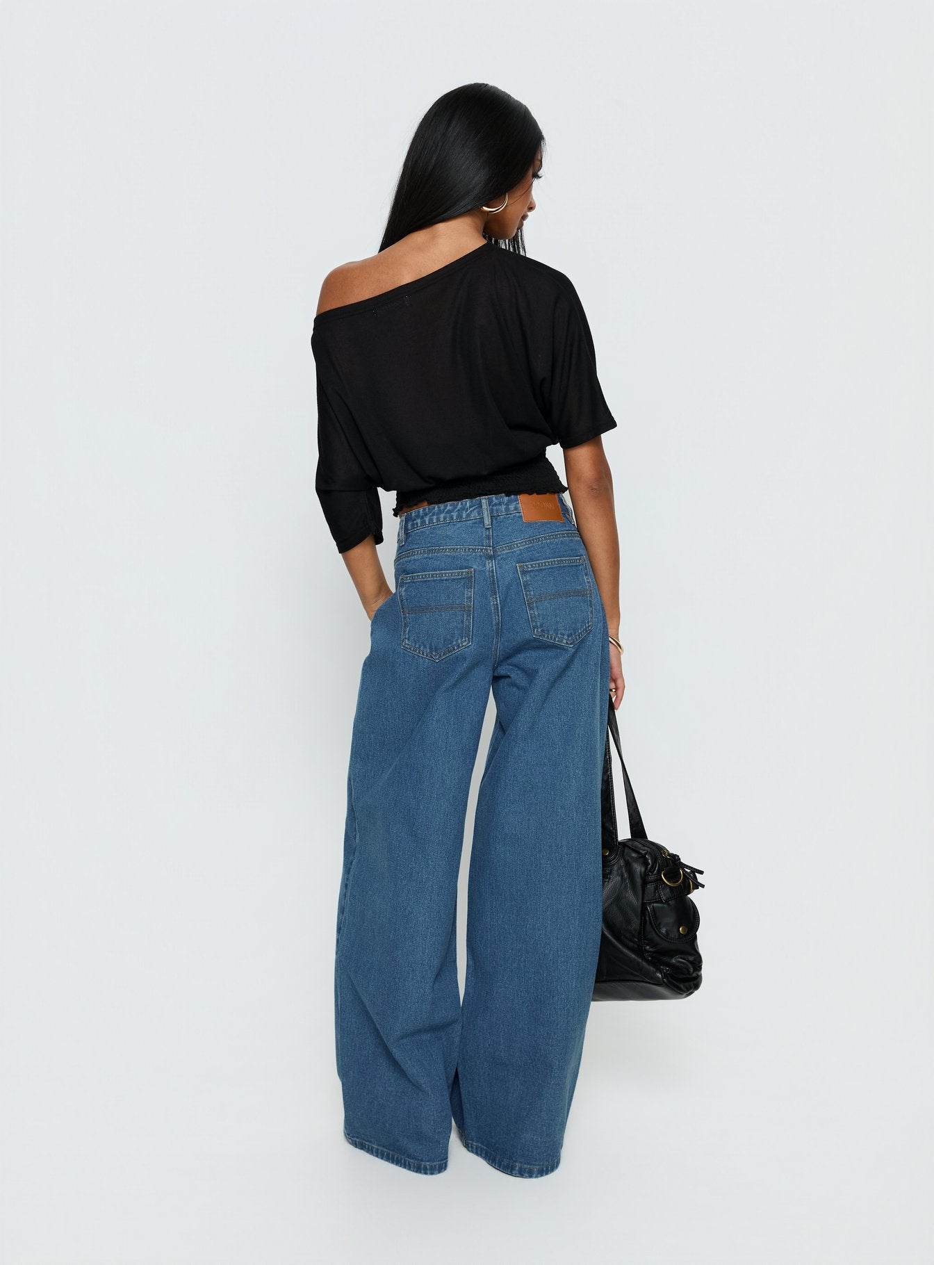 back view of model wearing Princess Polly Naylor Mid Rise Wide Leg Jeans Mid Blue Wash Mid Rise Jeans 