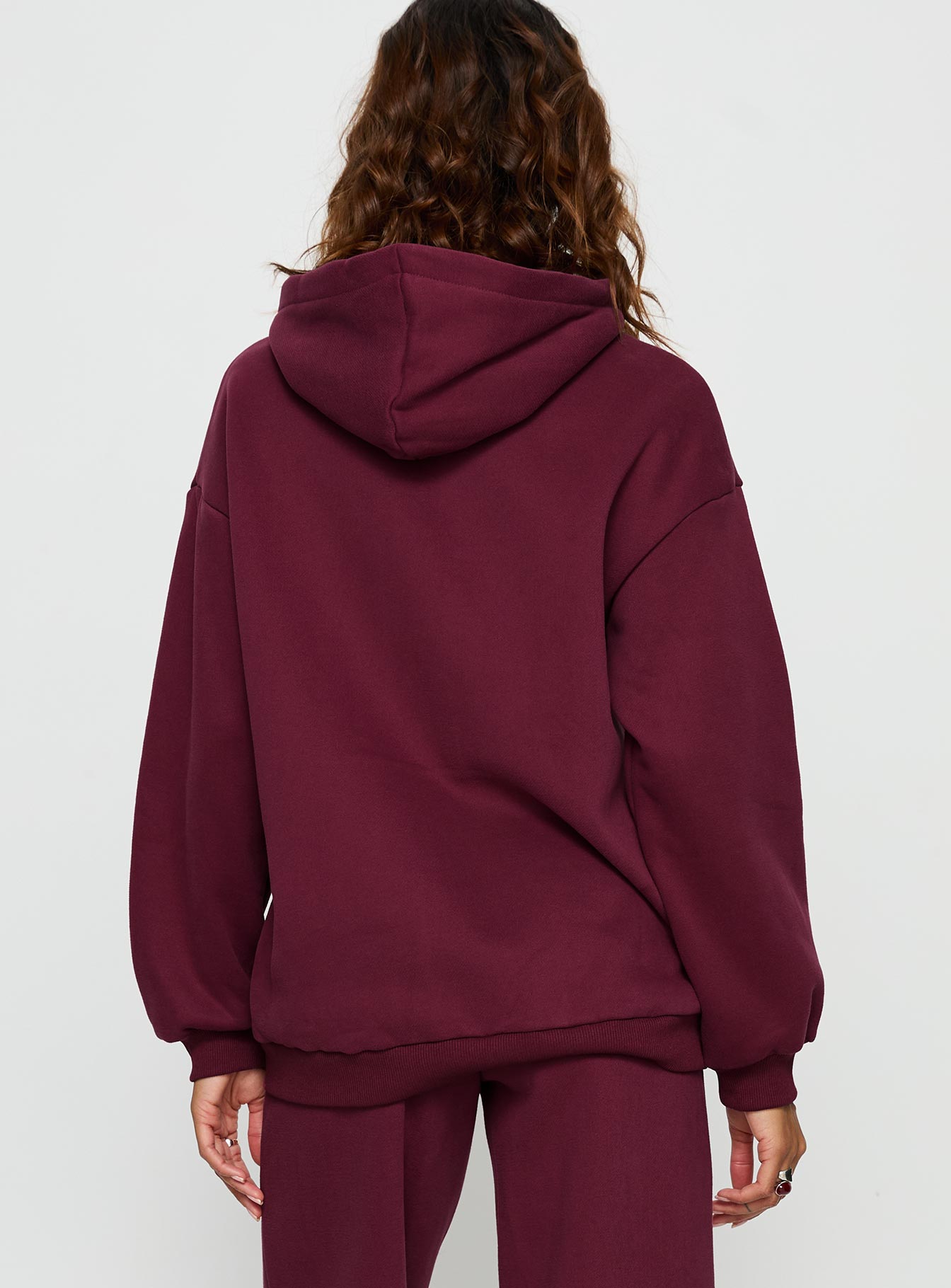 Elegantly presented Stargirl Zip Through Jumper in burgundy womens jumpers with long oversized fit, graphic print and hood back view of model wearing Princess Polly