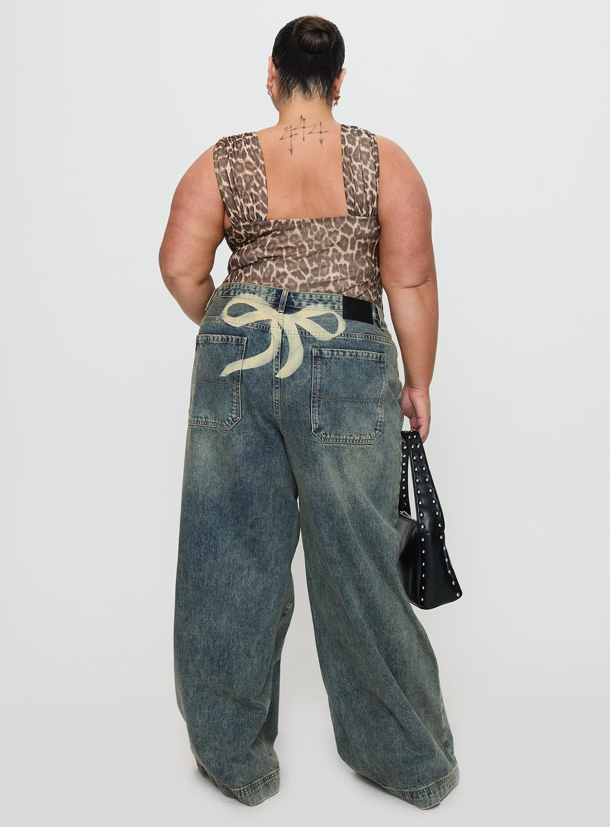 back view of model wearing Princess Polly Ribbon Stamp Wide Leg Jean Antique Wash Curve High Waisted 