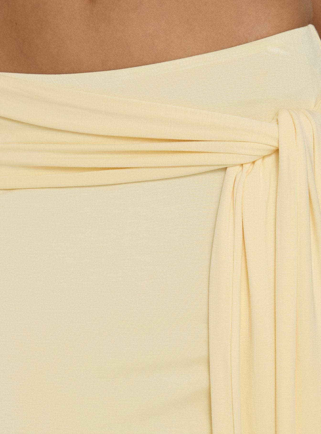 Close-up of the Aymee Tie Detail Maxi Skirt in Yellow, a women's skirt with relaxed fit, lace hem, solid print, aline shape, and wrap details Princess Polly