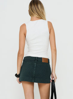 Presenting the Warna Low Rise Denim Mini Skirt Polka Dot womens-skirts in mini length, polkadot print, dark wash, aline shape, fitted fit, and frayed hem back view of model wearing Princess Polly