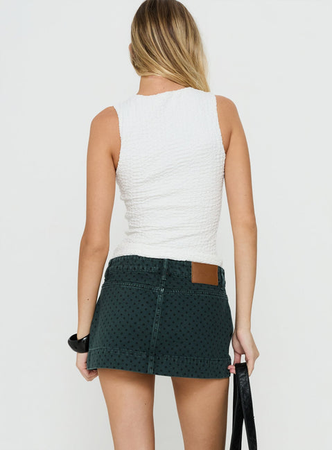 Presenting the Warna Low Rise Denim Mini Skirt Polka Dot womens-skirts in mini length, polkadot print, dark wash, aline shape, fitted fit, and frayed hem back view of model wearing Princess Polly