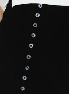 Highlighting the Leonelle Asymmetrical Button Mini Skirt Black womens-skirts in mini length detail view Princess Polly