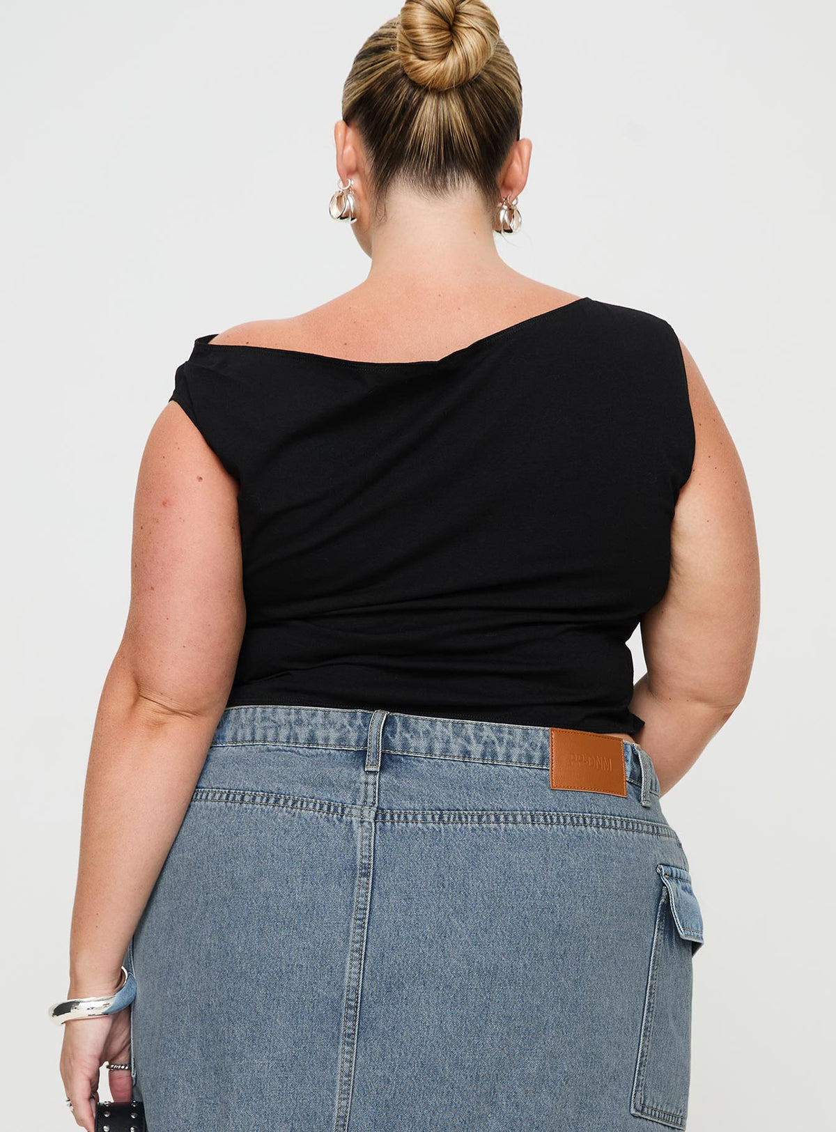 back view of model wearing Princess Polly Karre Off The Shoulder Top Black Curve Sleeveless Asymmetric Neckline 