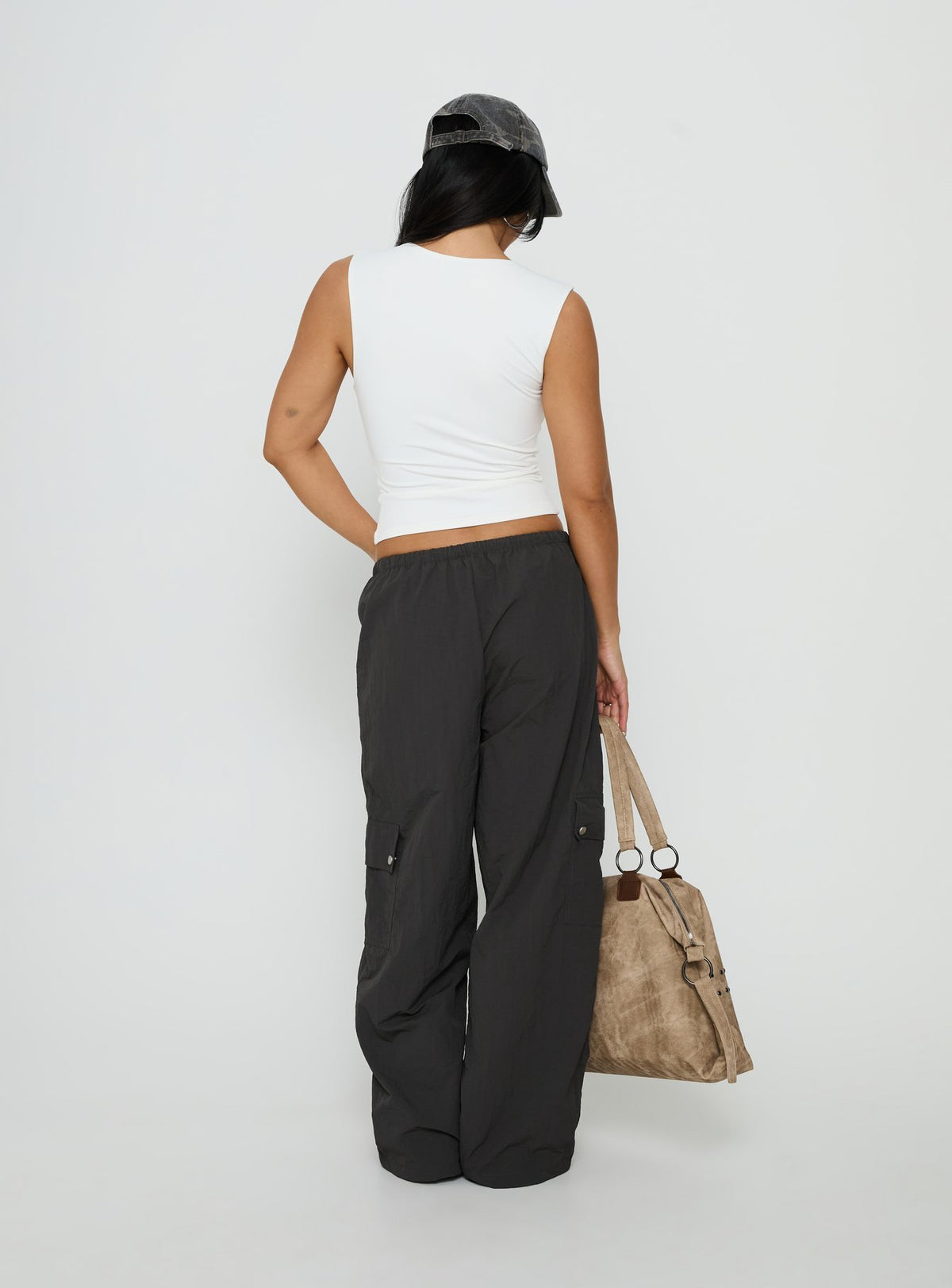 Highlighting the Lost On You Parachute Cargo Pants Charcoal in mid-rise womens-regular-pants back view of model wearing