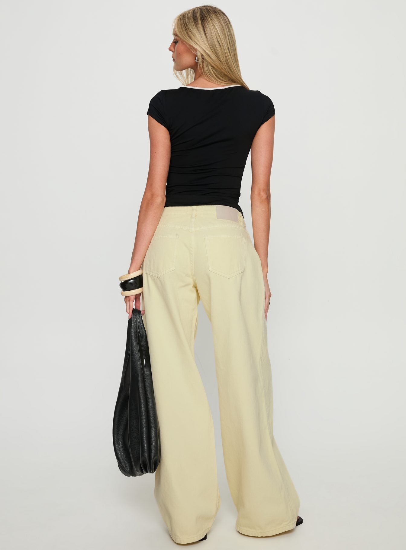 back view of model wearing Princess Polly Ramos Low Rise Wide Leg Jeans Butter Lemon Low Rise Jeans 