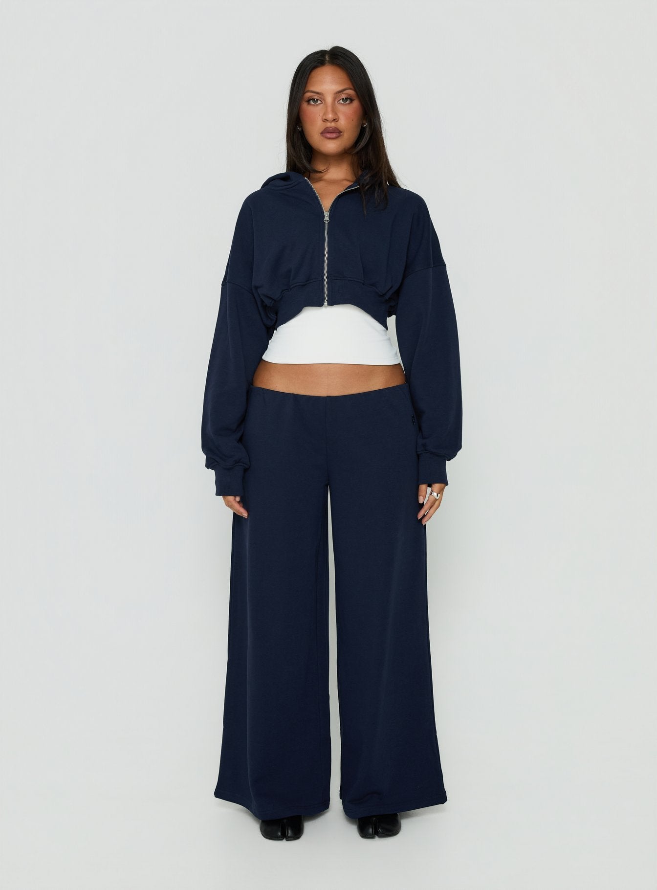 Showcasing the Kaeya Fleece Wide Leg Low Rise Pants Navy in womens regular pants with low-rise front view of model wearing Princess Polly
