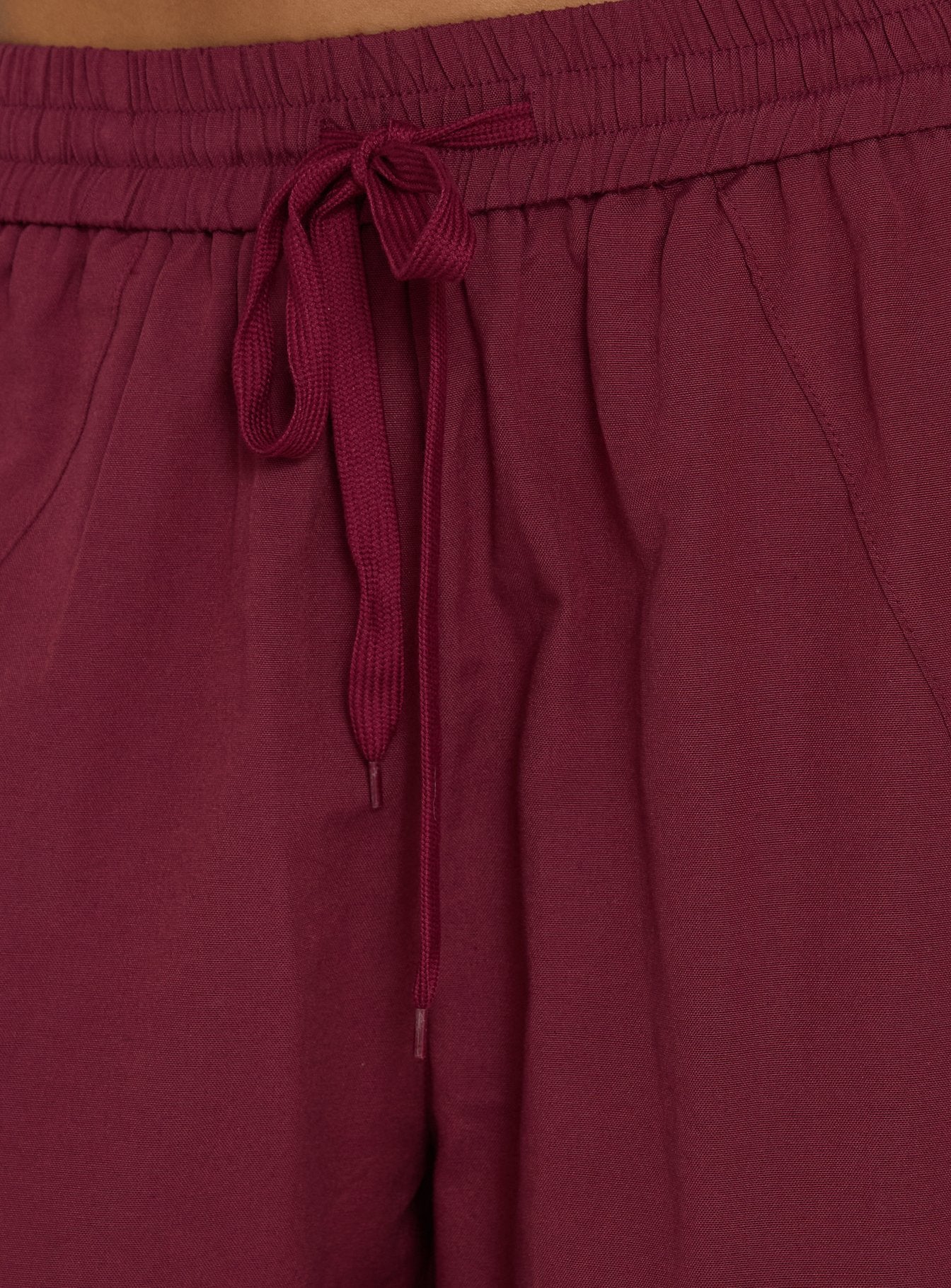 Featuring the Mankind Baggy Cargo Pants Red womens-regular-pants in mid-rise maroon detail view of model wearing Princess Polly