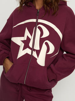 Highlighting the Stargirl Zip Through Jumper in burgundy womens jumpers with long oversized fit, graphic print and hood product Princess Polly