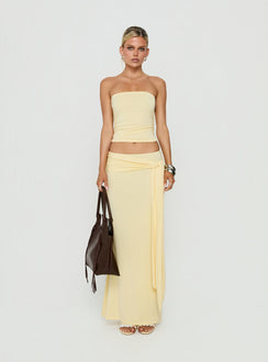 Showcasing the Aymee Tie Detail Maxi Skirt in Yellow, a women's skirt with relaxed fit, lace hem, solid print, aline shape, and wrap details front view of model wearing Princess Polly