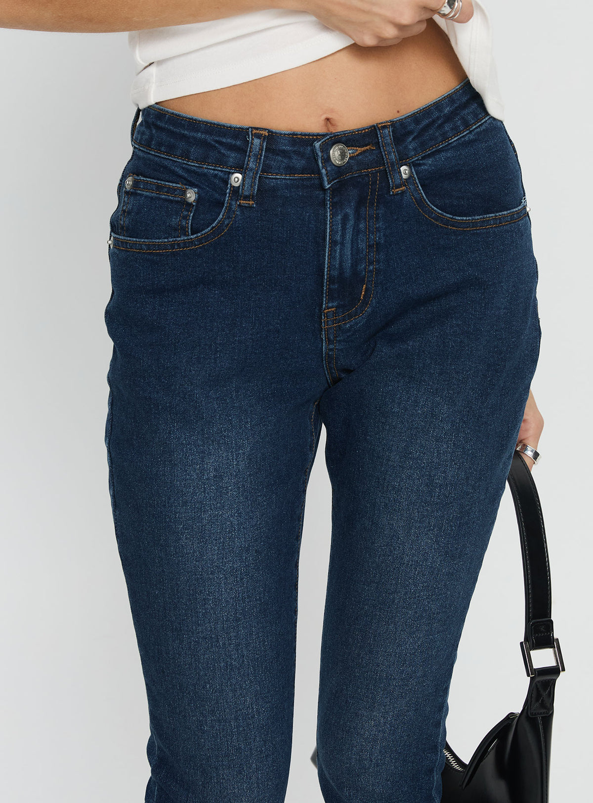 back view of model wearing Princess Polly Illyssa Mid Rise Skinny Jeans Mid Blue Wash Mid Rise Jeans 