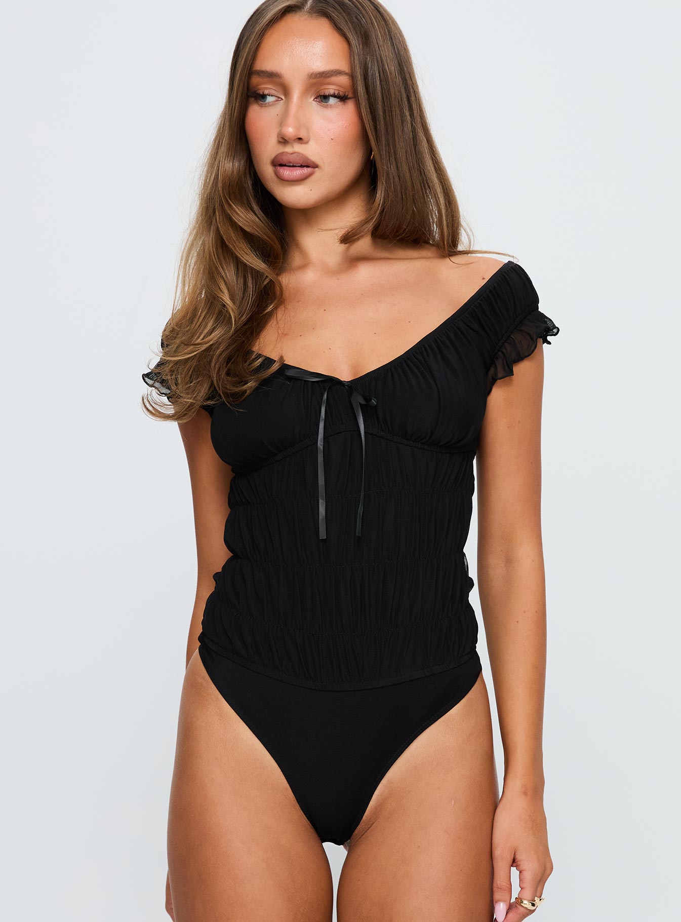 side view of model wearing Princess Polly Ahead Of Myself Off Shoulder Bodysuit Black Short Sleeves 