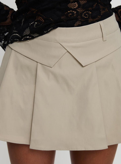 back view of model wearing Princess Polly Khaite Pleated Mini Skirt Beige Mini Skirts Skirts 