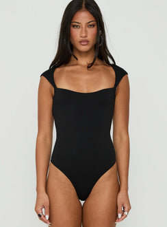 Showcasing the Fabienna Scoop Neck Cap Sleeve Bodysuit in black with short sleeves front view of model wearing Princess Polly