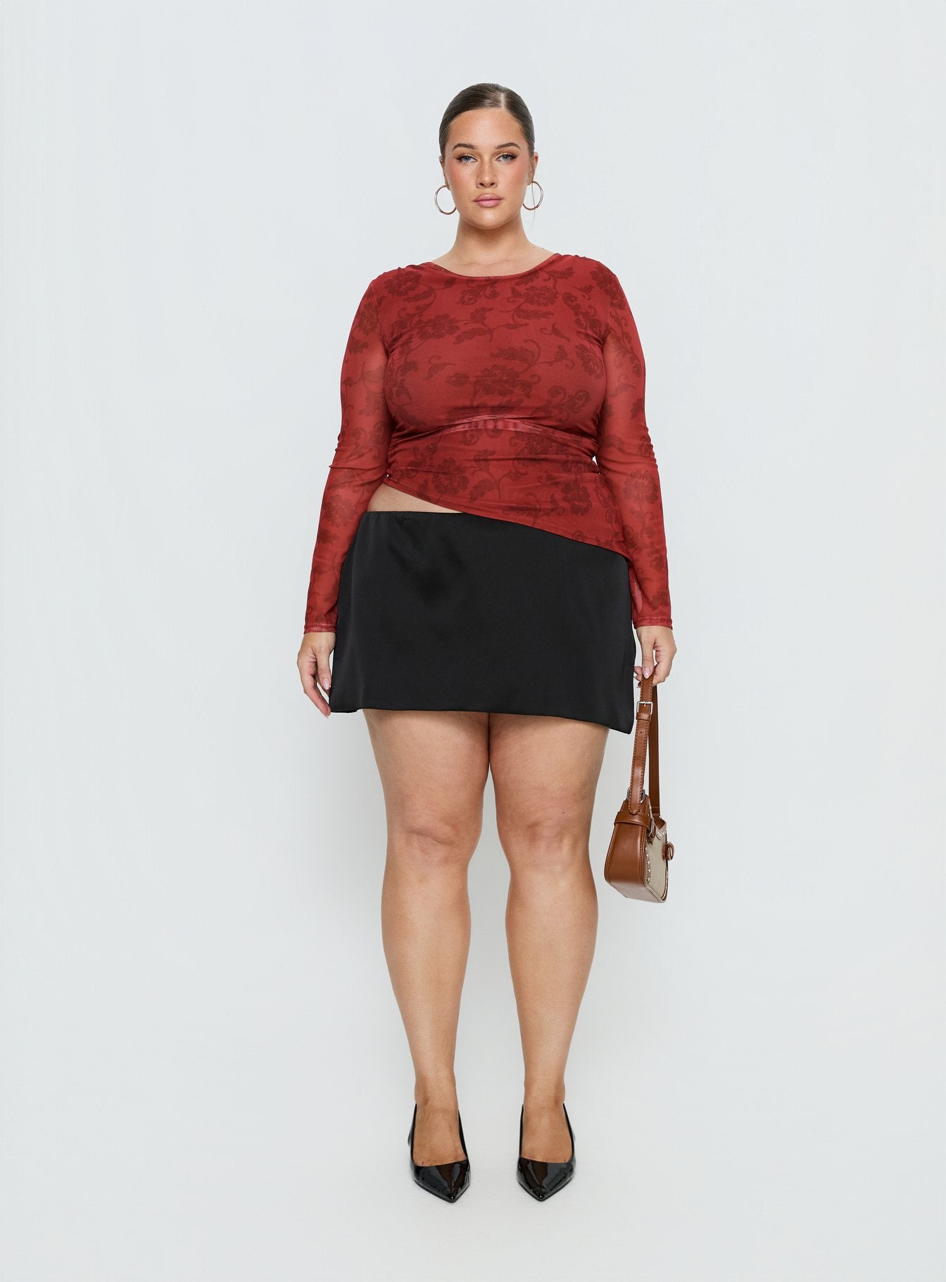   side view of model wearing Princess Polly Nadya Satin Tailored Mini Skirt Black Curve 