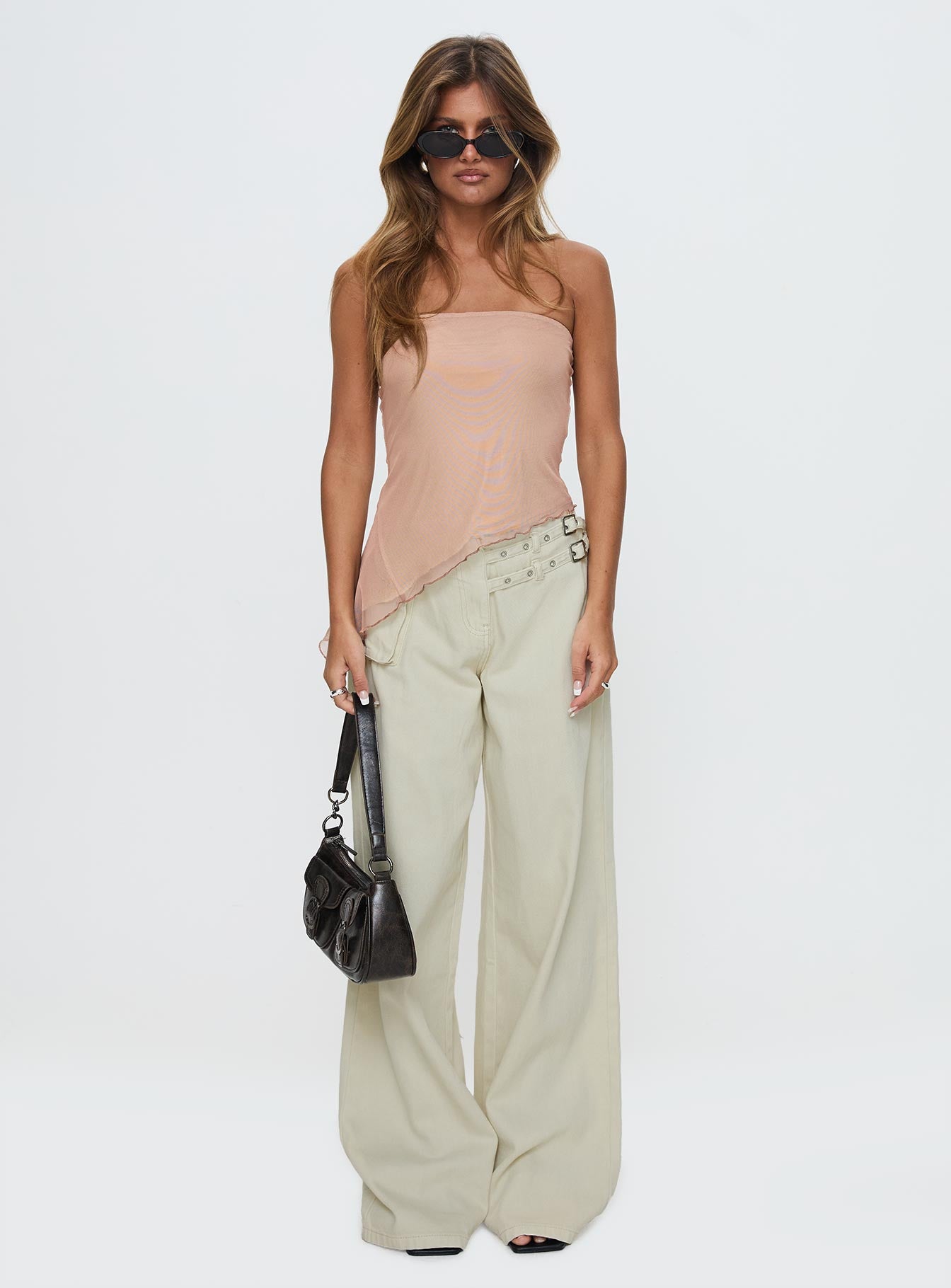 side view of model wearing Princess Polly Paxon Asymmetrical Top Beige Sleeveless straight 