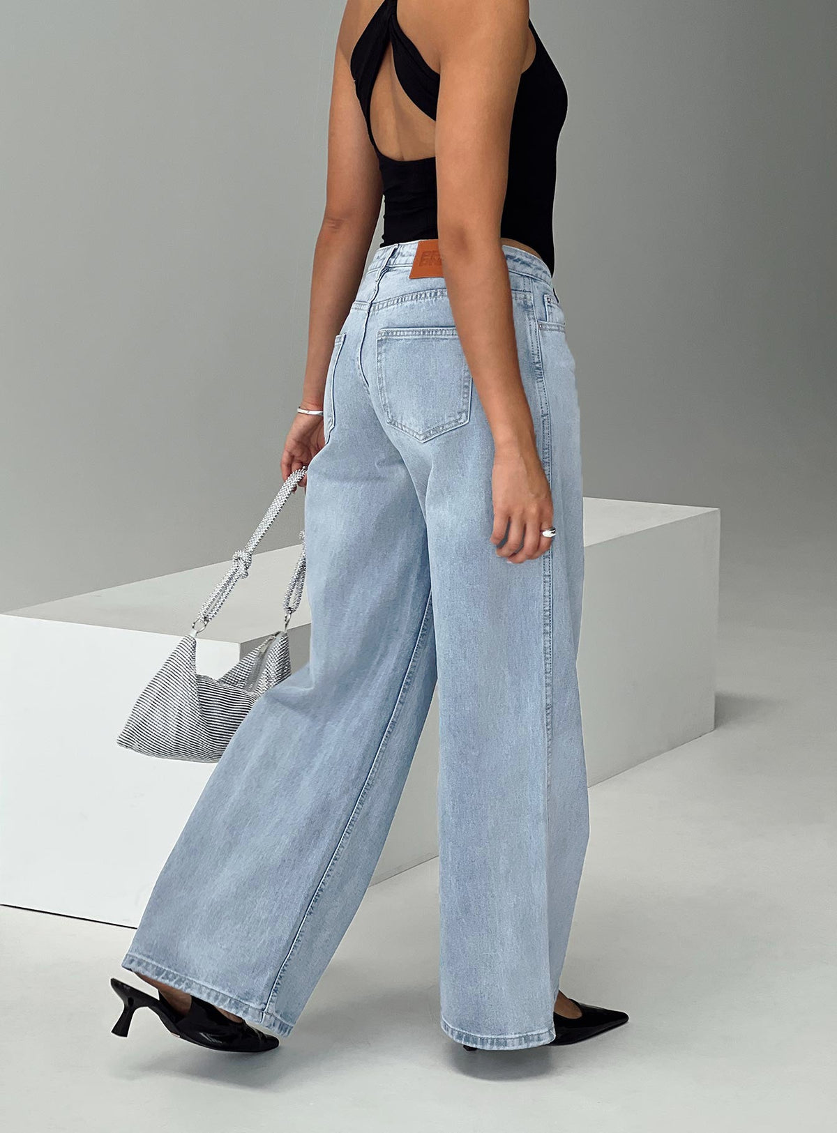 back view of model wearing Princess Polly Ramos Low Rise Denim Jeans Light Wash Petite Low Rise Jeans 