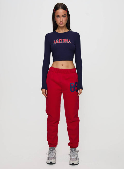 side view of model wearing Princess Polly U of A Bring It Back Long Sleeve Top Navy Full Sleeves Crew Neck 