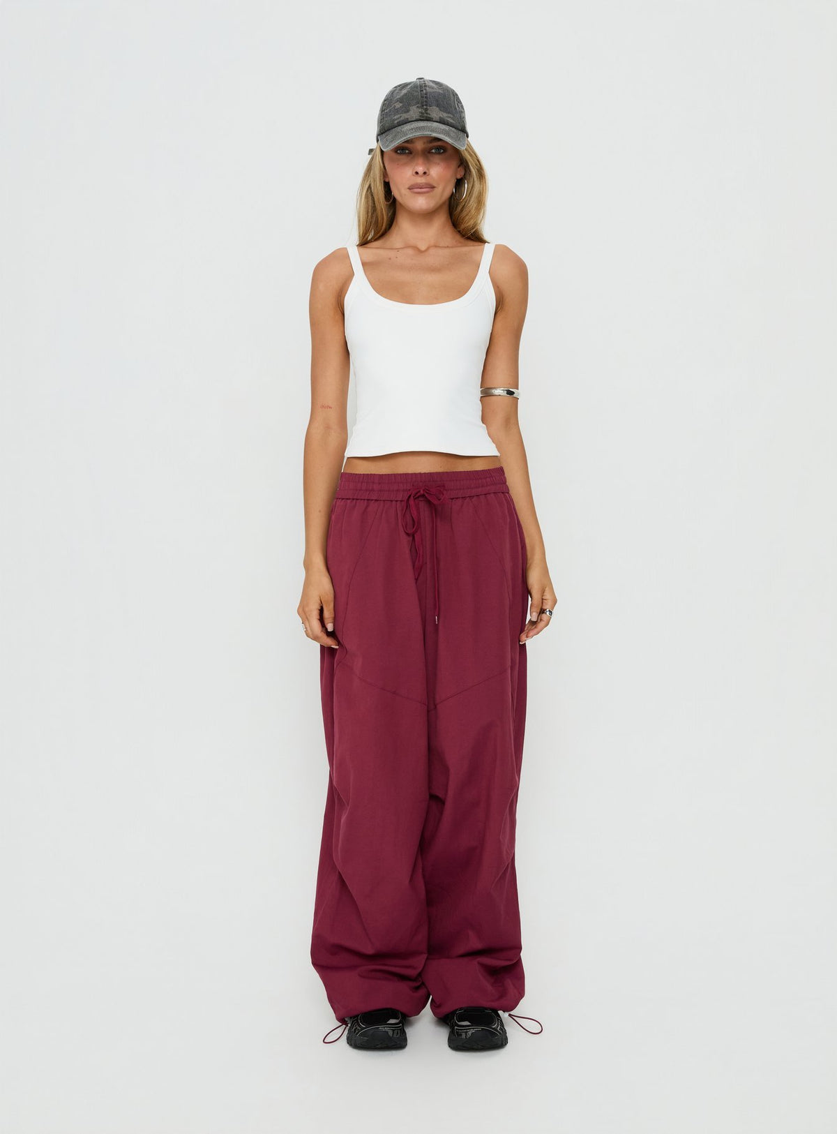Showcasing the Mankind Baggy Cargo Pants Red womens-regular-pants with mid-rise waist front view of model wearing Princess Polly