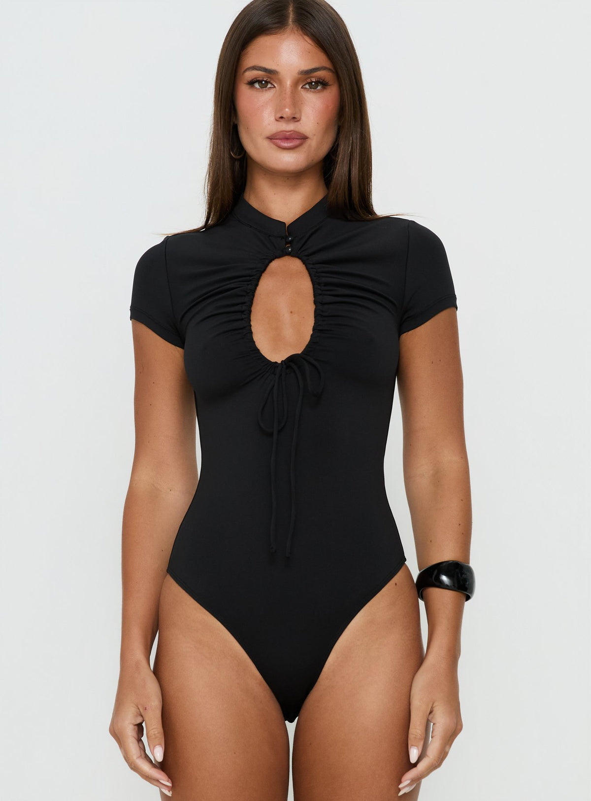 Showcasing the Maeci Ruched Tie Detail Bodysuit Black in womens-bodysuit with short sleeves, high-neck keyhole neckline front view of model wearing Princess Polly