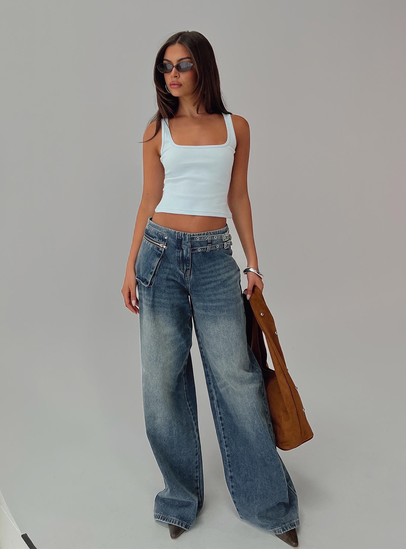 back view of model wearing Princess Polly Paltrow Mid Rise Wide Leg Cargo Jeans Mid Blue Wash Petite Mid Rise Jeans 