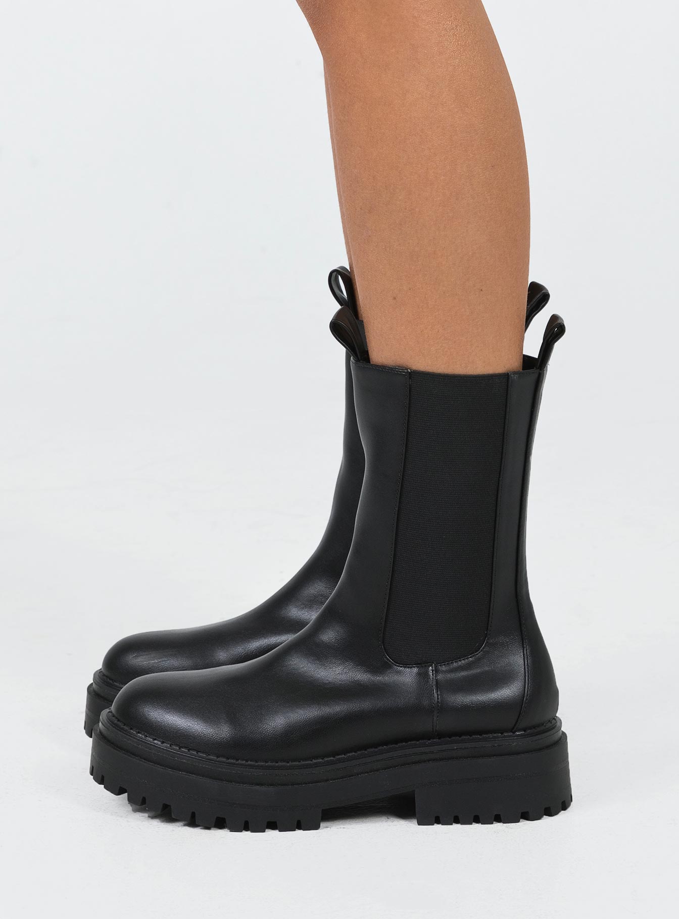 Boots Faux leather material Rounded toe Platform base Ankle pull tab Slip on style