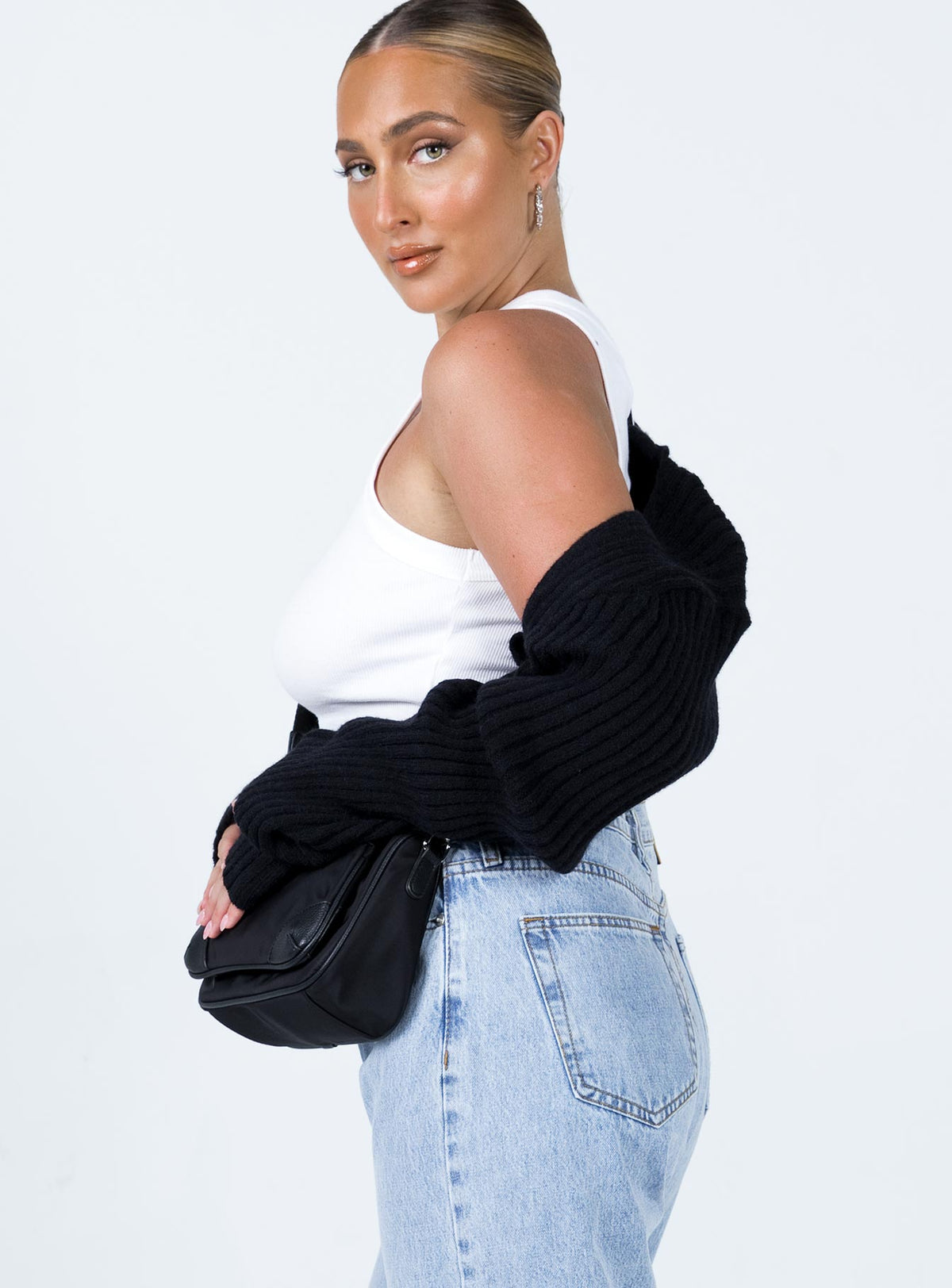 Styled with the Aytan Bolero Sweater in Black, a short jumper designed with cold shoulder details, side view of model wearing Princess Polly